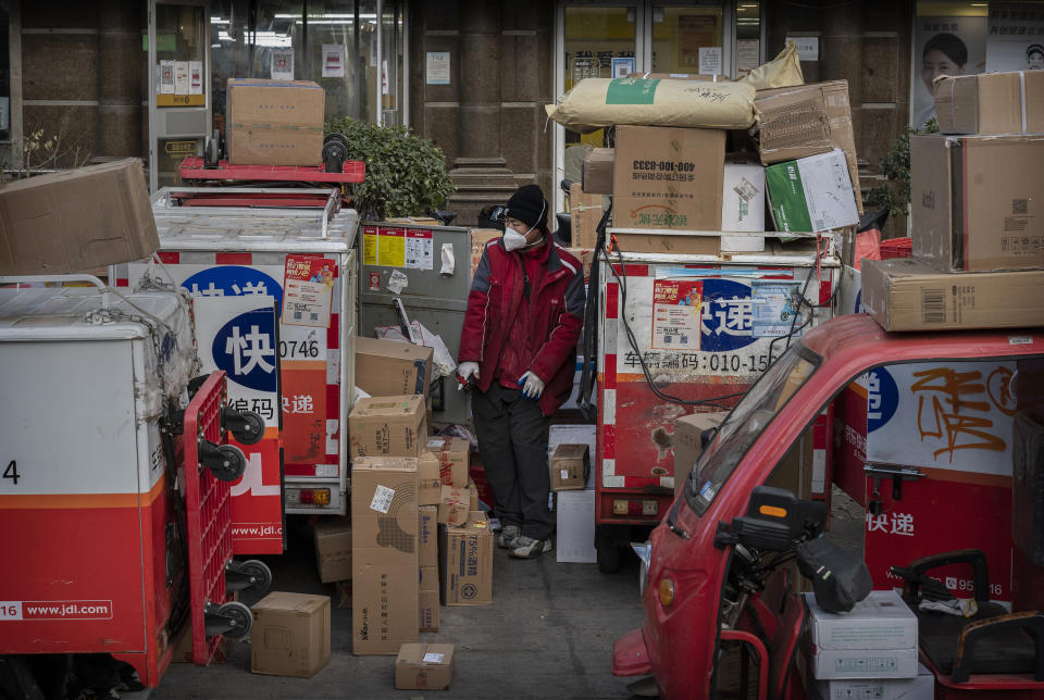 BEIJING, CHINA - DECEMBER 21: A delivery driver stands amongst packages in the street that are part of a backlog due to COVID-19 outbreaks outside a depot on December 21, 2022 in Beijing, China. The rapid spread of the virus across China has left many delivery services short-staffed as drivers become infected, impacting the supply chain. Chinas capital has seen a surge in COVID-19 cases since the government lifted its strict zero tolerance measures to contain the virus earlier this month. (Photo by Kevin Frayer/Getty Images)