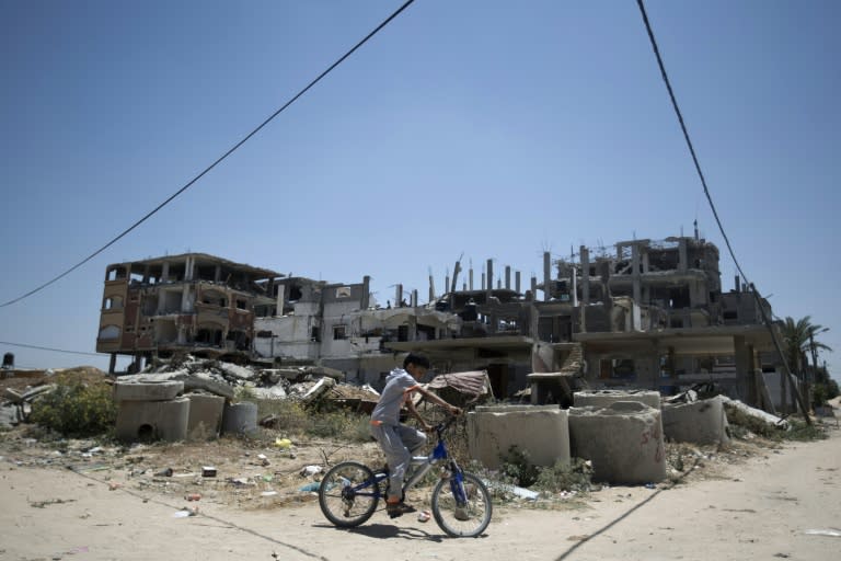 A Palestinian boy rides his bicycle July 3, 2015, past the rubble of buildings destroyed during the 50-day war between Israel and Hamas' militants in the summer of 2014 in the Beit Hanun, northern Gaza Strip