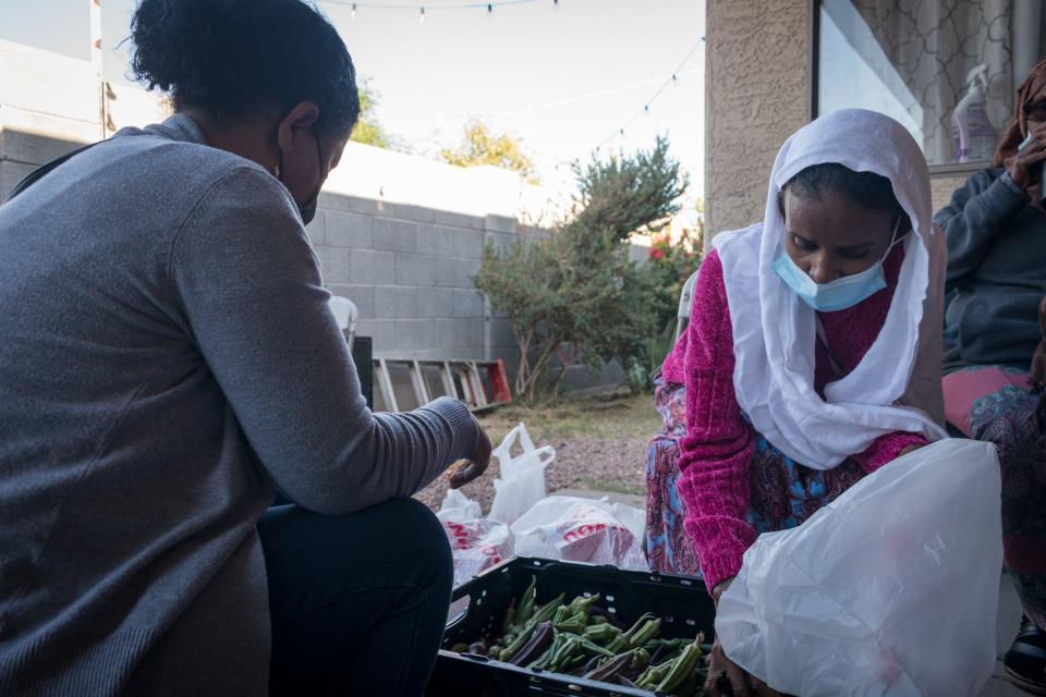 Eden Weldetinsae and Tsega Woldemichal separate the okra into bags on Nov. 13, 2021, in Phoenix.