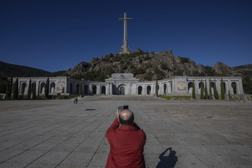 In this Tuesday, Sept. 24, 2019 photo, a visitor takes a snapshot at the Valley of the Fallen mausoleum near El Escorial, outskirts of Madrid, Spain. After a tortuous judicial and public relations battle, Spain's Socialist government has announced that Gen. Francisco Franco's embalmed body will be relocated from a controversial shrine to a small public cemetery where the former dictator's remains will lie along his deceased wife. (AP Photo/Bernat Armangue)