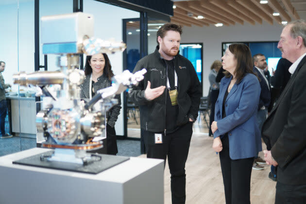 IonQ engineer Walker Steere discusses quantum computing with Sen. Maria Cantwell at IonQ’s Bothell facility. An early version of IonQ’s vacuum chamber for trapped ions is in the foreground. (IonQ Photo)