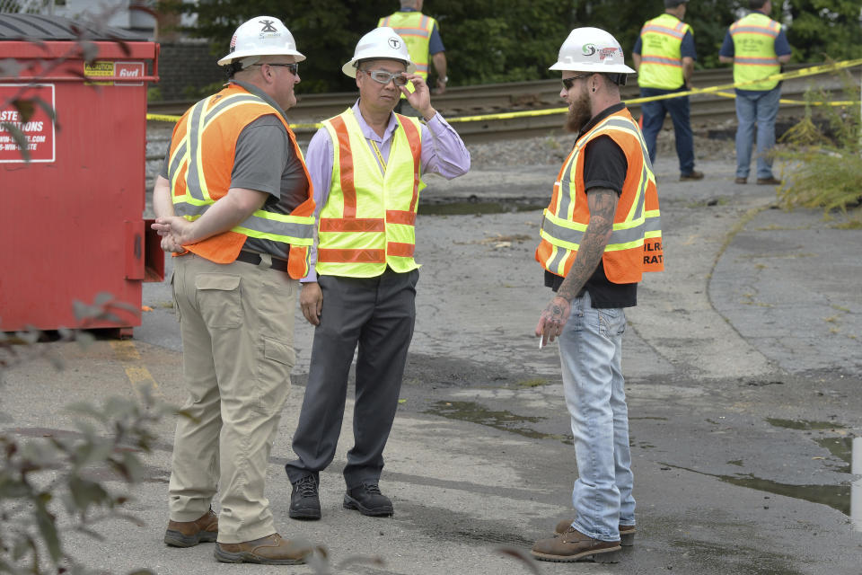 Phillip Eng, General Manager and CEO of the Massachusetts Bay Transportation Authority, second from left, speaks with crews surveying damage to a Commuter Rail train linewhich was washed out Tuesday, Sept. 12, 2023, in Leominster, Mass. after heavy rain fall in the town overnight. (AP Photo/Josh Reynolds)