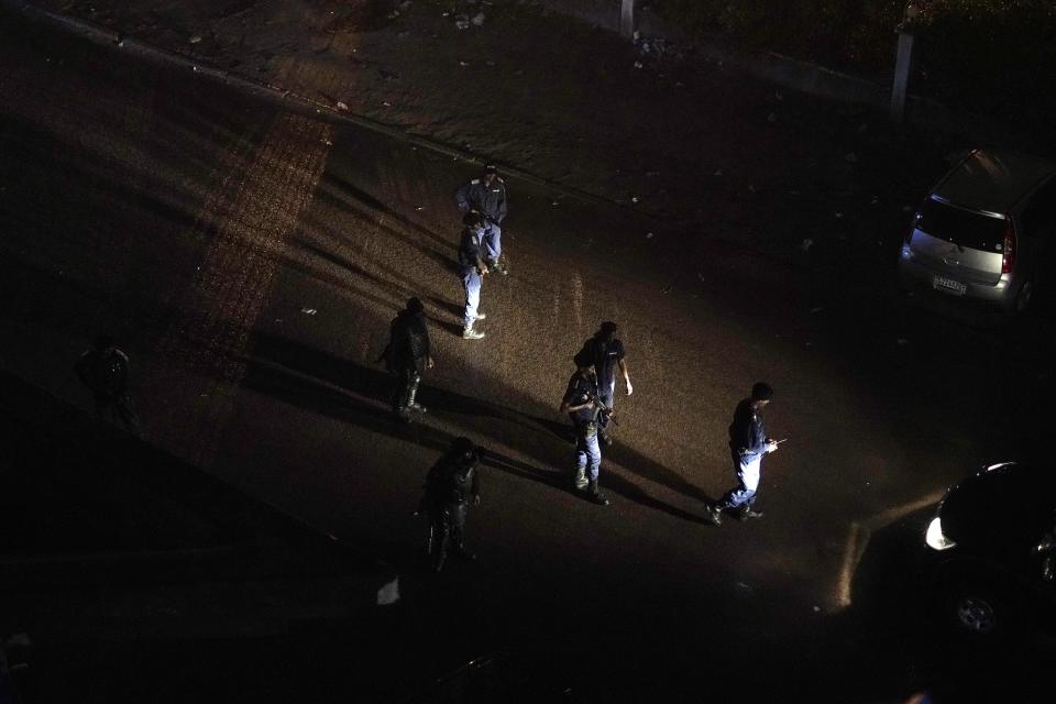 Congolese riot police take position around the electoral commission building at night in Kinshasa, Congo, Tuesday Jan. 8, 2019. As Congo anxiously awaits the outcome of the presidential election, many in the capital say they are convinced that the opposition won and that the delay in announcing results is allowing manipulation in favor of the ruling party. (AP Photo/Jerome Delay)