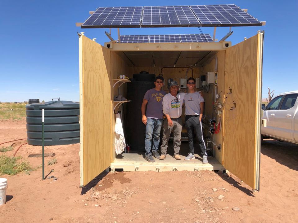 Peter Zhou, Stacey Jensen, and Jesus Solis (left to right) stand inside the Water Box, a solar-powered water desalination unit, in North Leupp Family Farms.