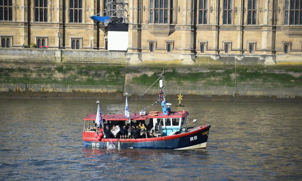 The ‘Fishing for Leave’ boat passes the Houses of Parliament on the Thames in London.