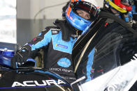 Ricky Taylor climbs in his car while practicing a driver change for the Rolex 24 hour auto race at Daytona International Speedway, Friday, Jan. 28, 2022, in Daytona Beach, Fla. (AP Photo/John Raoux)