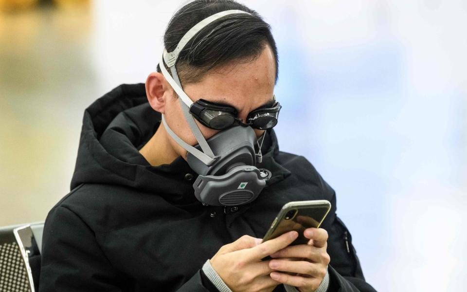 A traveller wears protective gear waiting for the high speed train between Hong Kong and China  - AFP