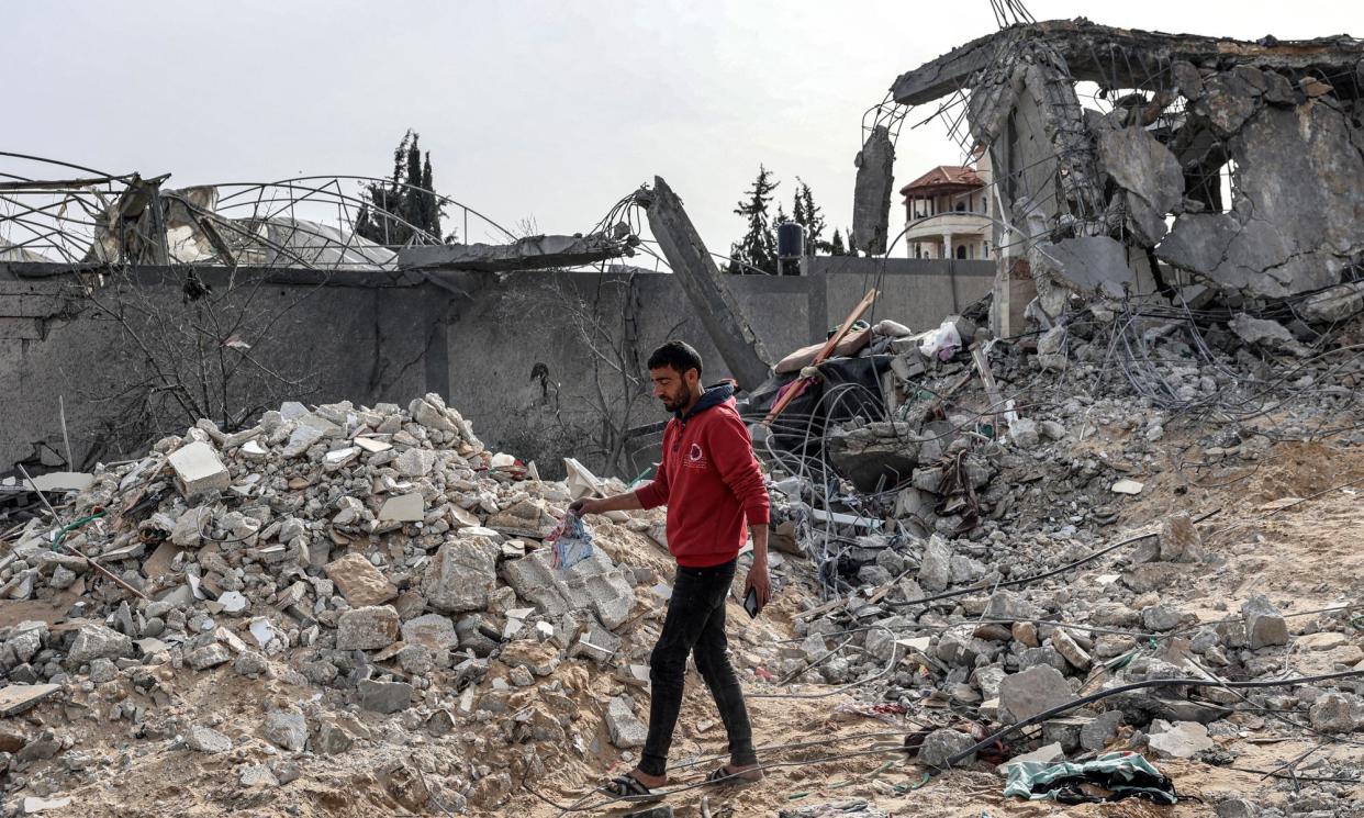 <span>A man walks amid the rubble of a building hit during Israeli bombardment in Rafah.</span><span>Photograph: Said Khatib/AFP/Getty Images</span>