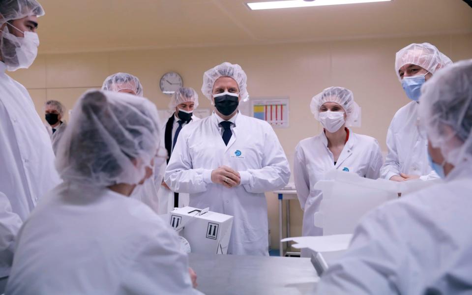 French President Emmanuel Macron, center, talks to employees as he visits the Delpharm plant in Saint-Remy-sur-Avre, west of Paris - Christophe Ena/AP Pool