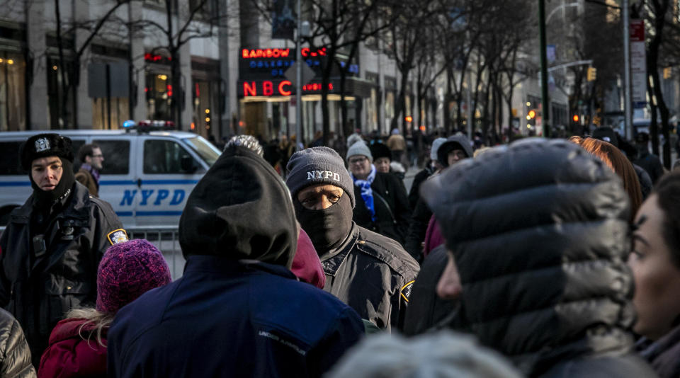 In this Thursday, Dec. 19, 2019 photo, NYPD officers patrol the surrounding areas at Rockefeller Center in New York. The area had seen a recent appearance of costumed performers soliciting money for photos, but unlike Times Square—where the city passed a law relegating the characters to 8-by-50 foot "activity zones," no such zones exist around Rockefeller Center and its iconic Christmas tree. (AP Photo/Bebeto Matthews)