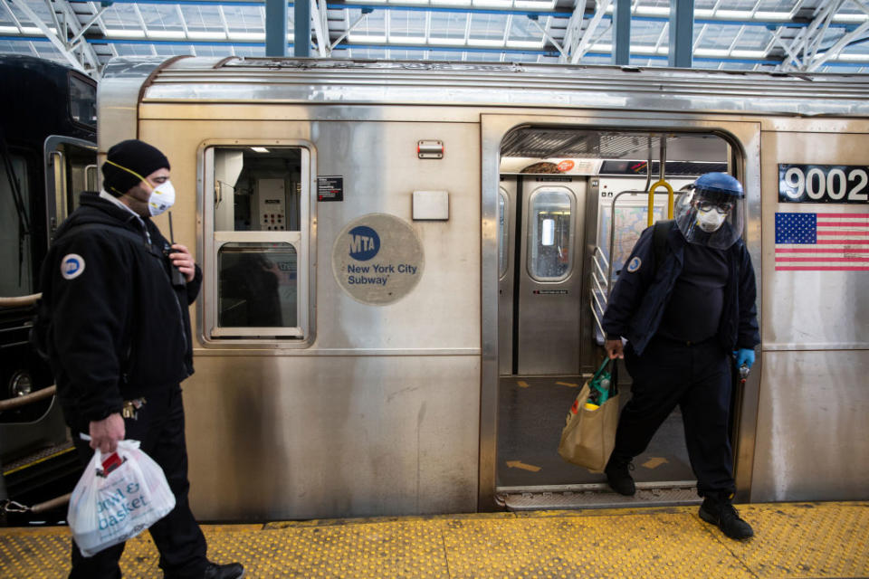 Metropolitan Transit Authority (MTA) workers wearing protective masks walk through the Coney Island subway. Source: Getty