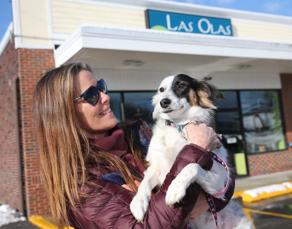 Julie Burke rescued Juno, a dog from Nicaragua, seen here in front of Las Olas Taqueria in Hampton Tuesday, Jan. 24, 2023.  Julie and Matt Burke, owners of Las Olas, are donating six acres of land to an organization they founded in Nicaragua that rescues and treats animals in need.
