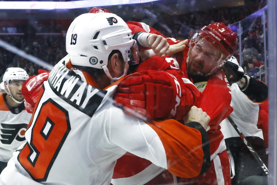 Detroit Red Wings defenseman Justin Holl (3) tries to punch Philadelphia Flyers right wing Garnet Hathaway (19) during the first period of an NHL hockey game Friday, Dec. 22, 2023, in Detroit. (AP Photo/Duane Burleson)