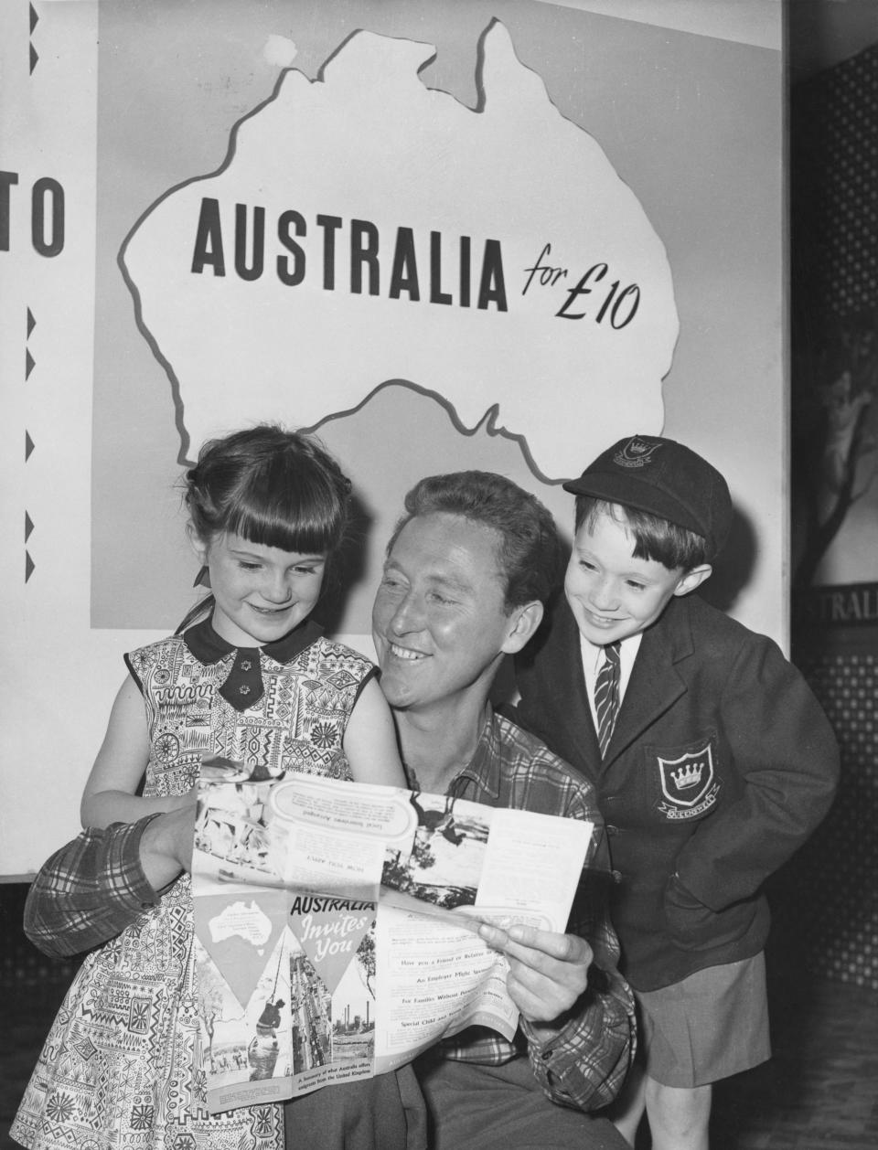 Australian-born actor Vincent Ball chats to Martin and Anna Williams at the Australian exhibit at the Boys and Girls Exhibition at Olympia, London, 28th August 1956. The children are about to emigrate to Sydney with their parents, under the government-assisted 'Ten Pound Poms' scheme. (Photo by Ron Case/Keystone/Hulton Archive/Getty Images)