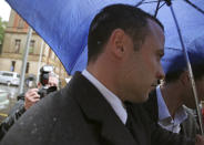 Oscar Pistorius arrives at the high court after the first day of his trial in Pretoria, South Africa, Tuesday, March 4, 2014. Pistorius is charged with murder with premeditation in the shooting death of girlfriend Reeva Steenkamp in the pre-dawn hours of Valentine's Day 2013. (AP Photo/Schalk van Zuydam)