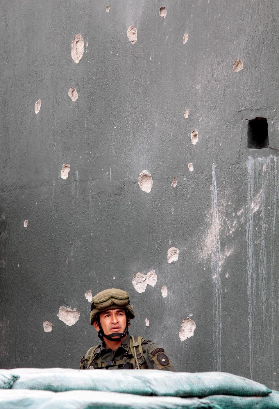 A police officer guards the police station in Toribio, southern Colombia, Wednesday, July 11, 2012. President Juan Manuel Santos visited the town, that was attacked by rebels of the Revolutionary Armed Forces of Colombia, FARC, last week. (AP Photo/Juan Bautista Diaz)