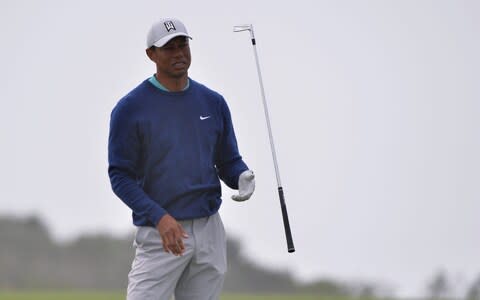 Tiger Woods flips his club after his shot on the fourth hole - Credit: USA Today