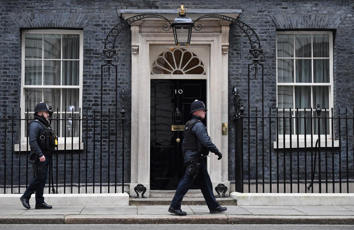 A police officer walks past the door to 10 Downing Street, the official residence of Britain’s prime minister, in London on 25 January 2022 (AFP via Getty Images)
