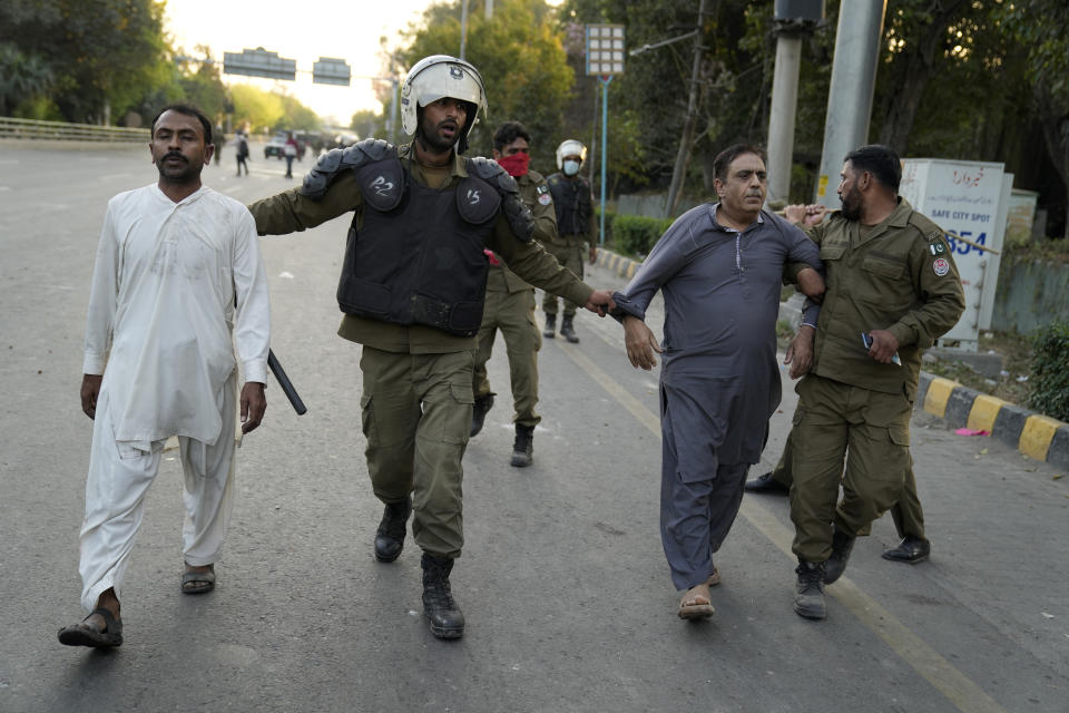 Police officers detain supporters of Pakistan's former Prime Minister Imran Khan during clashes, in Lahore, Pakistan, Wednesday, March 8, 2023. Pakistani police used water cannons and fired tear gas to disperse supporters of the country's former Prime Minister Khan Wednesday in the eastern city of Lahore. Two dozen Khan supporters were arrested for defying a government ban on holding rallies, police said. (AP Photo/K.M. Chaudary)