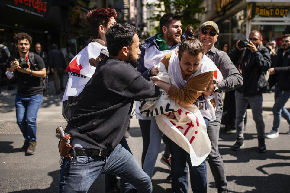 A plain clothes policeman scuffles with union members as they march during Labor day celebrations in Istanbul, Turkey, Monday, May 1, 2023. A six-party opposition alliance united behind the candidacy of Kemal Kilicdaroglu have declared their commitment for a return to parliamentary democracy and greater rights and freedoms should their alliance win the elections. (AP Photo/Emrah Gurel)