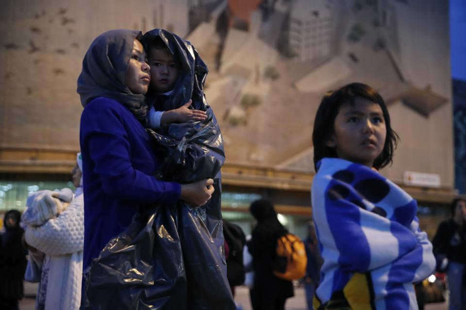 An Afghan woman holds her child upon their arrival from Lesbos island to the port of Piraeus, near Athens, Monday Oct. 7, 2019. In the last 24 hours 668 refugees and migrants have been transferred to mainland Greece from five Greek islands as authorities have accelerated efforts to ease over crowding in the camps. (AP Photo/Thanassis Stavrakis)