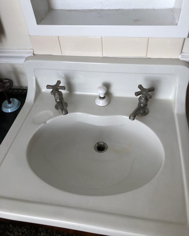 Pedestal sink in bathroom before renovation.