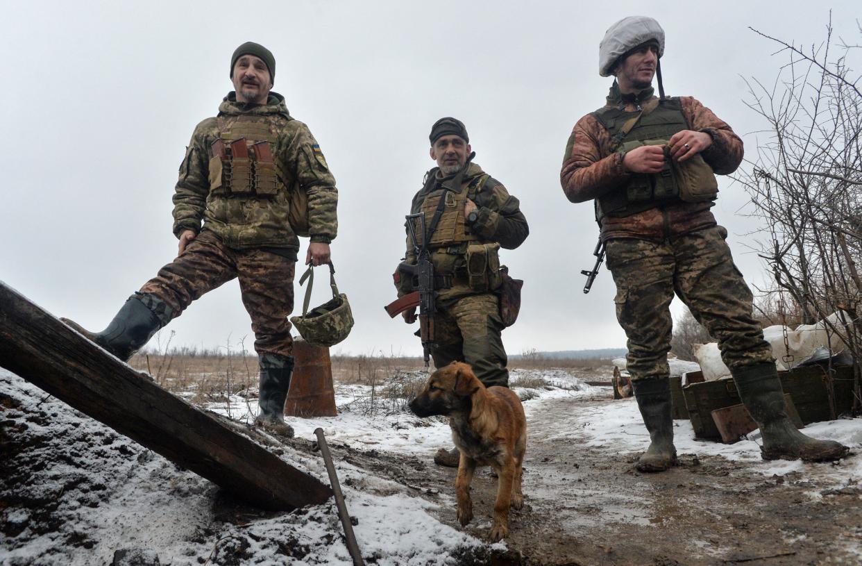 File photo: Service members of the Ukrainian armed forces stand next to a puppy at combat positions near the line of separation from Russian-backed rebels in the Donetsk region, Ukraine (REUTERS)