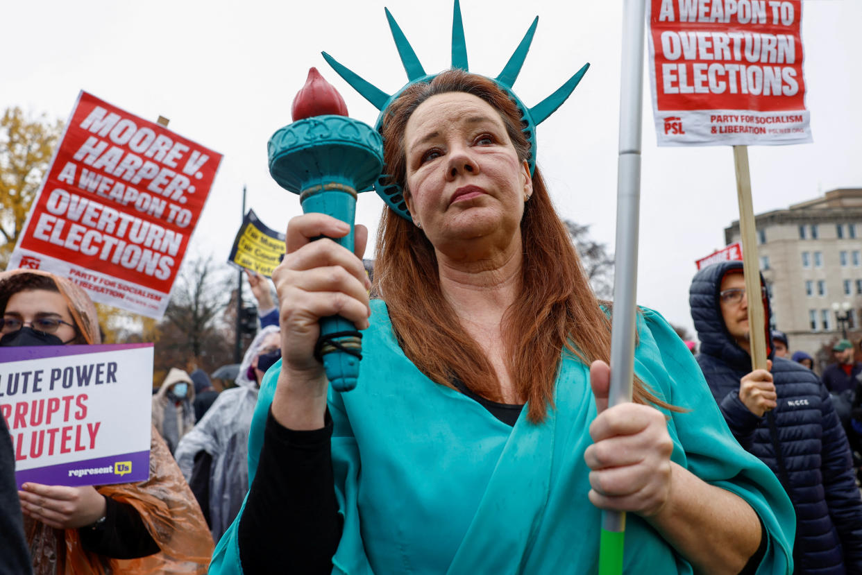 Laurie Woodward Garcia, from Florida, demonstrates outside the Supreme Court as the justices hear oral arguments in Moore v. Harper.