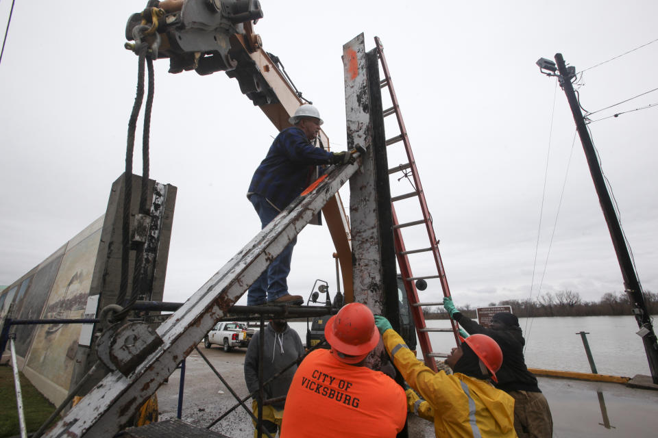 Workers with the City of Vicksburg start construction on one of the three flood wall gates on Levee Street in Vicksburg Miss., on Thursday Feb. 21, 2019. According to the National Weather Service the Mississippi River is currently at 44.69 feet and is expected to reach 48.9 feet. (Courtland Wells/The Vicksburg Post, via AP)