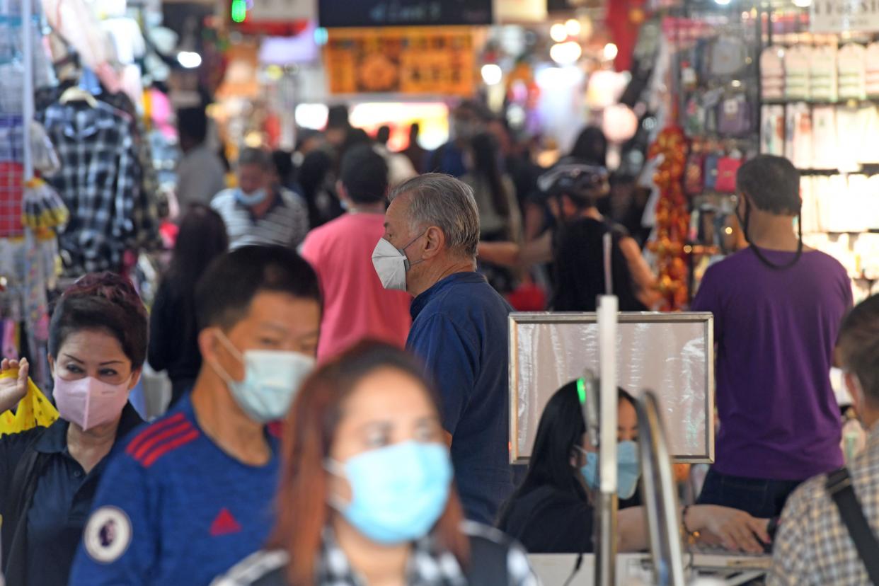 People wearing masks hang out at a shopping area in the city centre of Singapore, Jan 20, 2022. (Photo by Then Chih Wey/Xinhua via Getty Images)