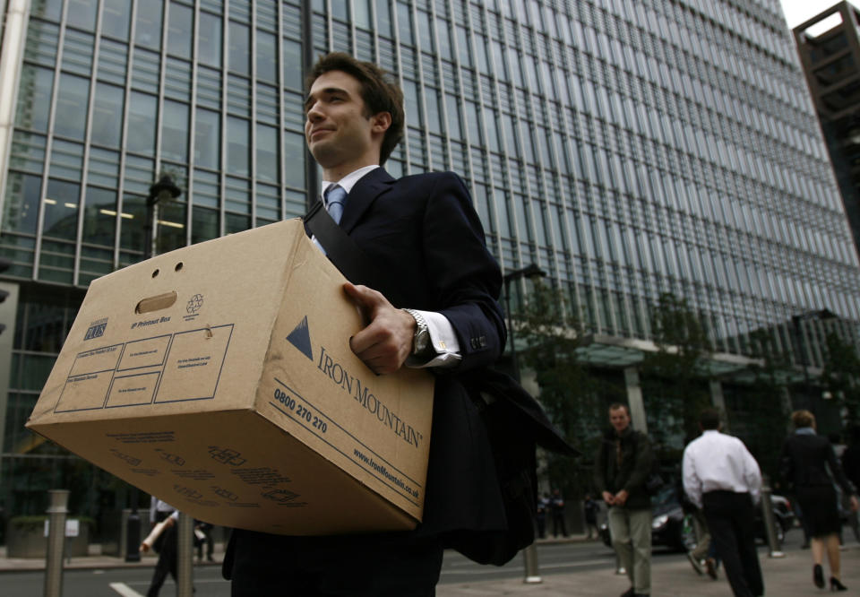 A worker carries a box out of the U.S. investment bank Lehman Brothers offices in the Canary Wharf district of London September 15, 2008. REUTERS/Andrew Winning (BRITAIN) - GM1E49F1UDB01