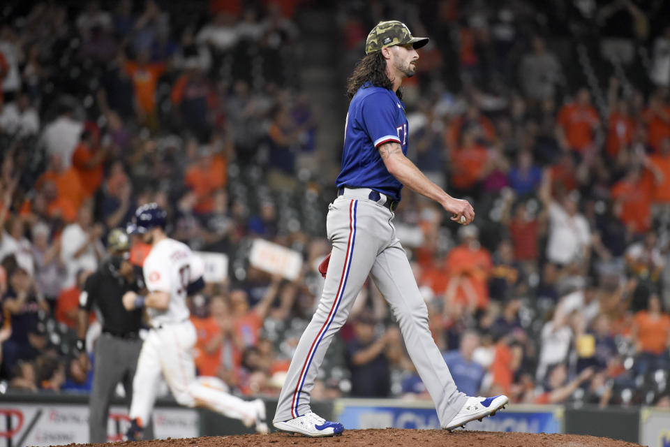 Texas Rangers relief pitcher Hunter Wood, right, walks off the mound as Houston Astros' Kyle Tucker, back left, rounds the bases after hitting a two-run home run during the seventh inning of a baseball game, Saturday, May 15, 2021, in Houston. (AP Photo/Eric Christian Smith)