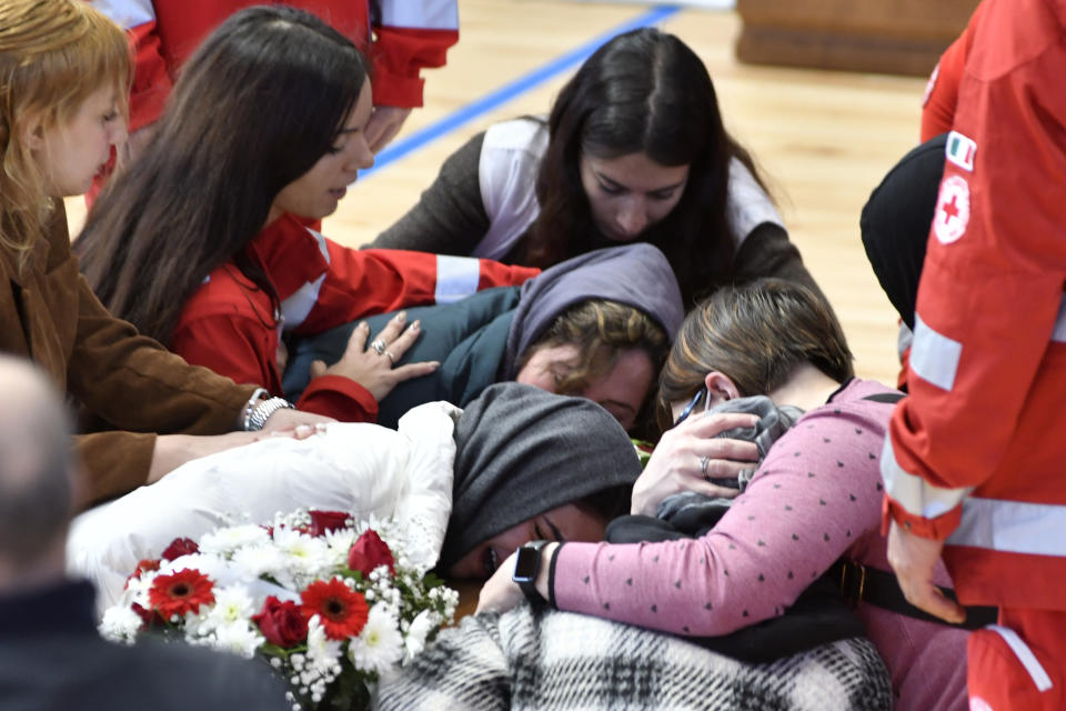 Relatives cry on the coffin of one of the victims of last Sunday's shipwreck at the local sports hall in Crotone, southern Italy, Wednesday, March 1, 2023. At least 67 people, including 14 minors, died when their overcrowded wooden boat slammed into shoals 100 meters (yards) off the shore of Cutro and broke apart early Sunday in rough seas. Eighty people survived, but many more are feared dead since survivors indicated the boat had carried about 170 people when it set off last week from Izmir, Turkey. (AP photo/Giuseppe Pipita)