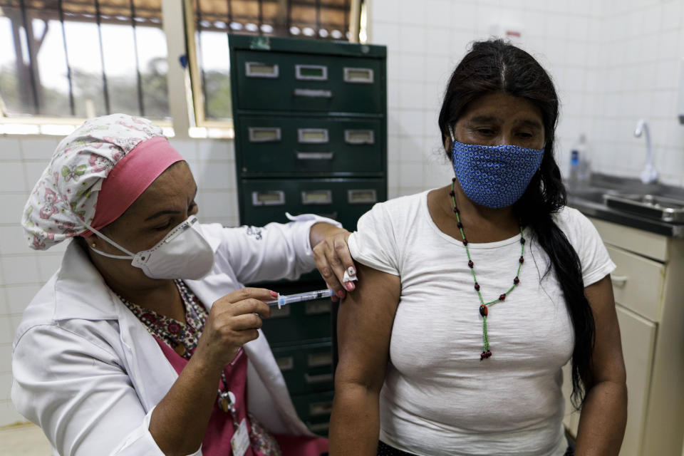 An Tenonde Pora Indigenous woman gets a shot of China's Sinovac CoronaVac vaccine for COVID-19 in Tenonde Pora village, on the outskirts of Sao Paulo, Brazil, Wednesday, Jan. 20, 2021. (AP Photo/Marcelo Chello)