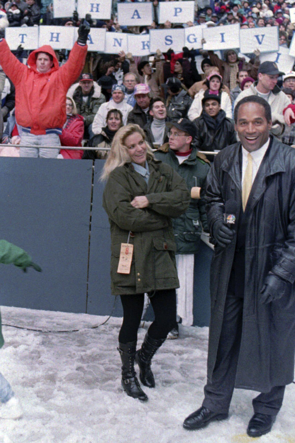 FILE - O.J. Simpson wears gloves as he stands with his wife Nicole on the sidelines of Texas Stadium in Irving, Texas, during the Thanksgiving Day NFL football game between the Dallas Cowboys and the Miami Dolphins on Nov. 24, 1993. Simpson, the decorated football superstar and Hollywood actor who was acquitted of charges he killed his former wife and her friend but later found liable in a separate civil trial, has died. He was 76. (AP Photo/Ron Heflin, File)
