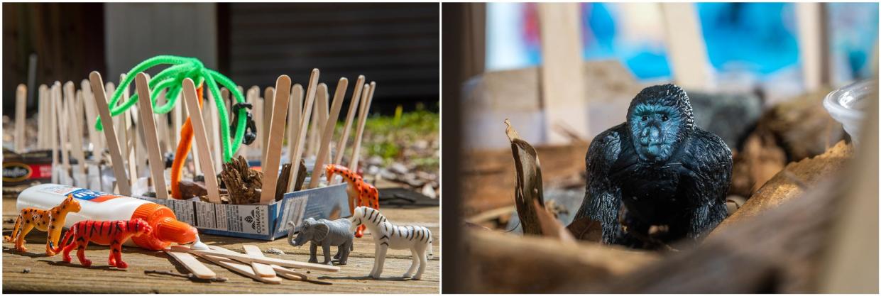 A boxed lid zoo is on display outside on a picnic table. Plastic safari animals are also shown such as a gorilla, zebra, giraffe and elephant. 