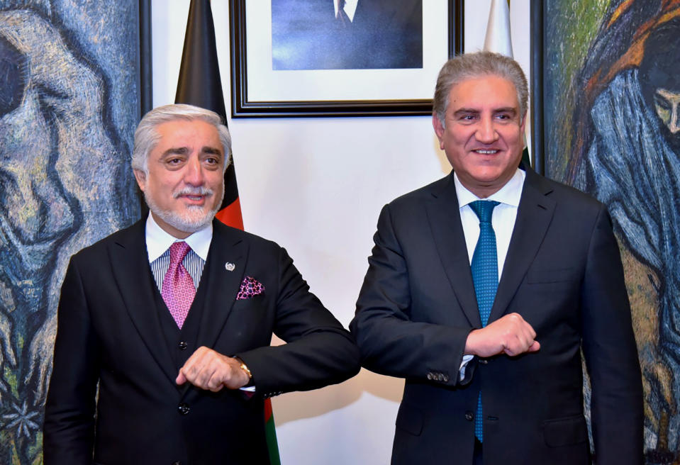 In this photo provided by Pakistan's Ministry of Foreign Affairs, Abdullah Abdullah, left, chairman of Afghanistan's High Council for National Reconciliation, bumps elbows with Pakistani Foreign Minister Shah Mahmood Qureshi, upon for a meeting, in Islamabad, Pakistan, Monday, Sept. 28, 2020. Afghanistan's top official in negotiations with the Taliban arrived in Pakistan's capital Monday on a three-day trip during which he will meet with the country's prime minister and other government officials. (Ministry of Foreign Affairs via AP)