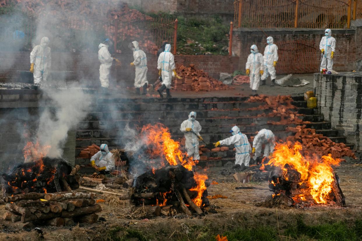 <p>File image:  In this 5 May, 2021 photo, Nepalese men in personal protective suits cremate the bodies of Covid-19 victims while others extend the crematorium as the number of deaths rise near Pashupatinath temple in Kathmandu, Nepal</p> (AP)