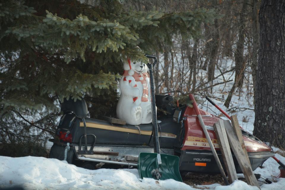 And old snowmobile and holiday decoration sits along the driveway of the Eau Claire Acres home in Gordon where Jayme Closs was allegedly held for months by Jake Patterson.