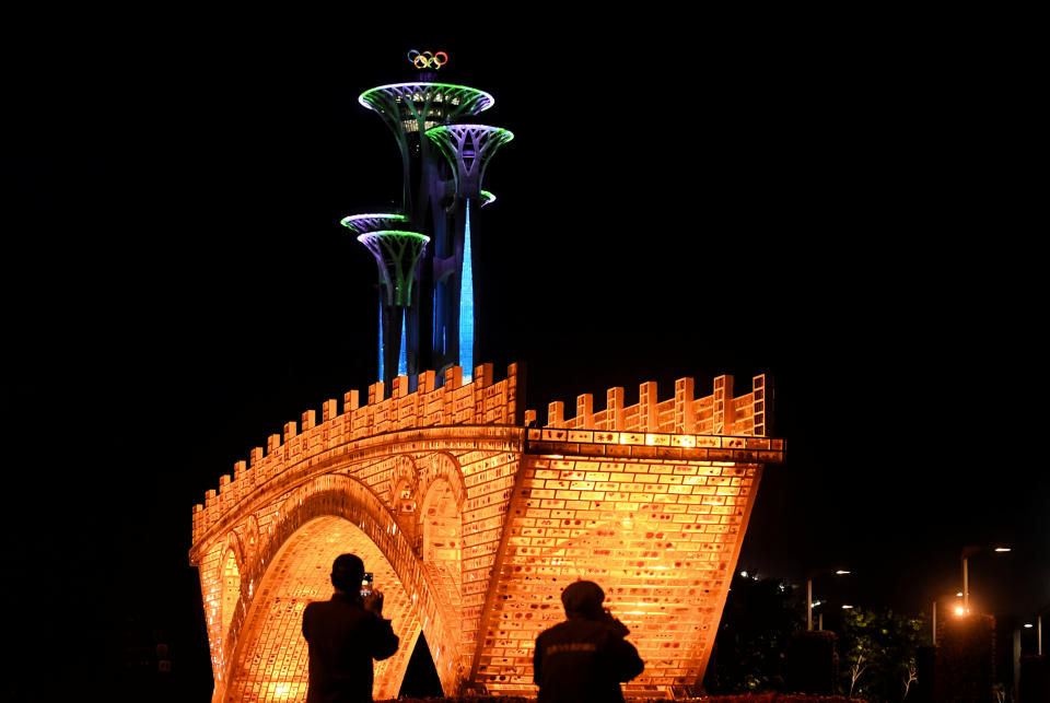 People take pictures in front of a "Golden Bridge on Silk Road" installation, set up ahead of the Belt and Road Forum, outside the National Convention Centre in Beijing, China May 11, 2017. Picture taken May 11, 2017. REUTERS/Stringer ATTENTION EDITORS - THIS IMAGE WAS PROVIDED BY A THIRD PARTY. EDITORIAL USE ONLY. CHINA OUT.