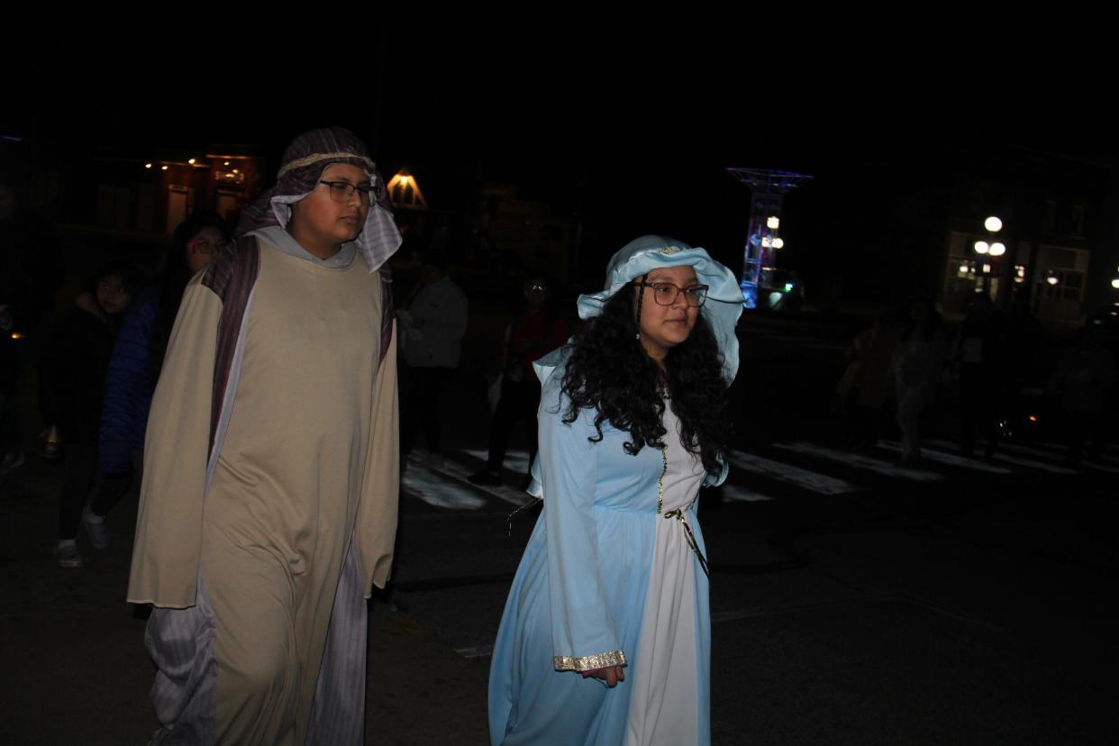 Siblings Jose and Katia Clemente, dressed as Joseph and Mary, lead the Las Posadas procession in Perry, Iowa. Las Posadas teaches about welcoming the stranger and building community.