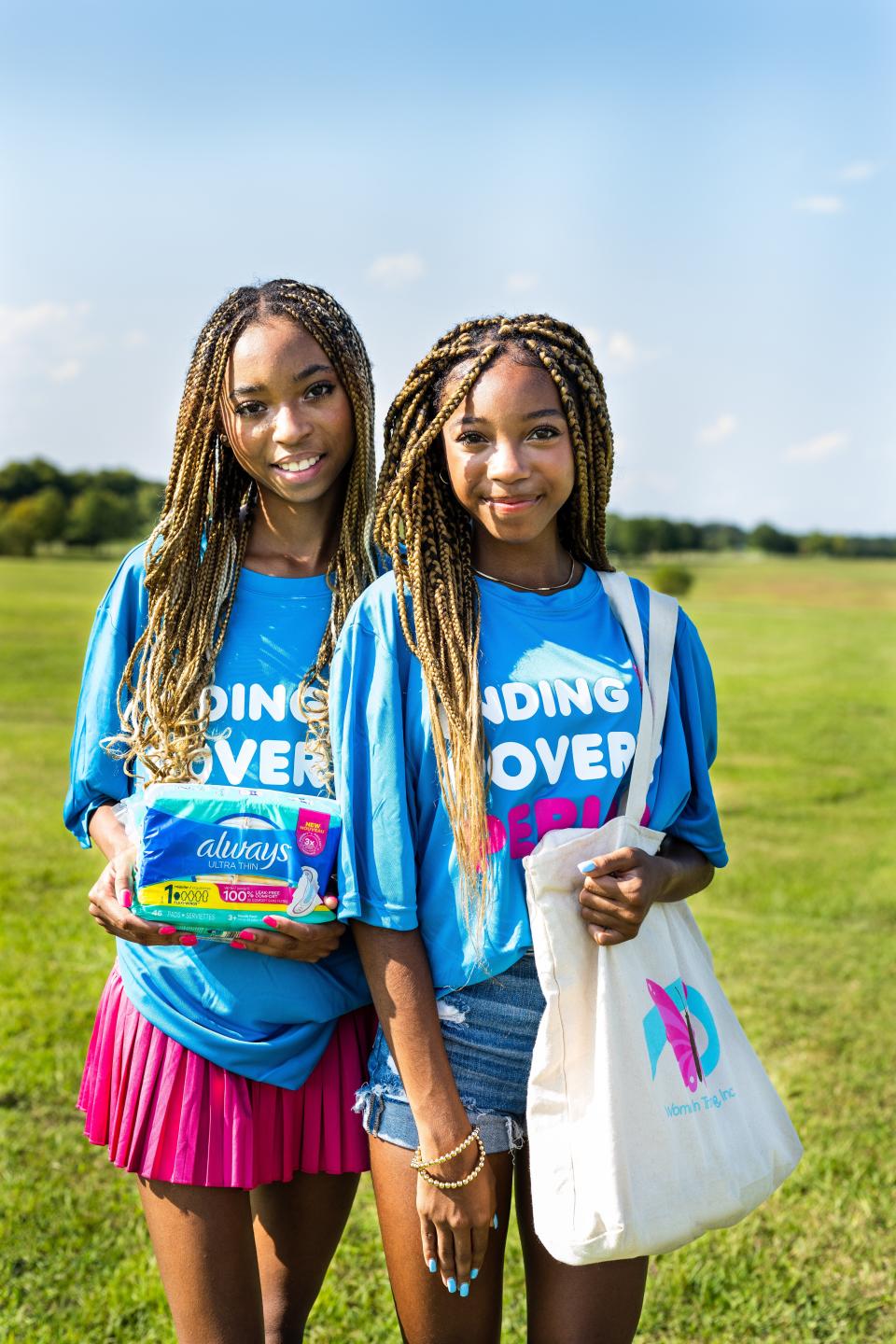 Brooke and Breanna Bennett, co-founders of Women in Training, Inc., receive a donation of Always pads to distribute to girls in their local community in Montgomery.
