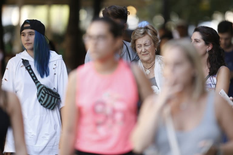 An elderly woman accompanied by young people reacts after a van ploughed into the crowd, killing two persons and injuring several others on the Rambla in Barcelona on August 17, 2017