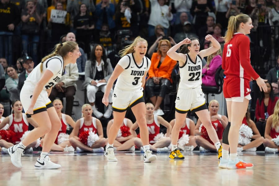 Iowa guards Kate Martin, left, Sydney Affolter (3) and Caitlin Clark (22) celebrate during overtime of an NCAA college basketball game against Nebraska in the final of the Big Ten women’s tournament Sunday, March 10, 2024, in Minneapolis. (AP Photo/Abbie Parr)
