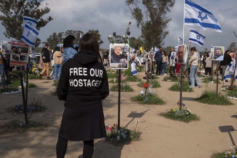 A woman wears a free hostages sweatshirt as she visits the memorial in Re'im, Israel, on Tuesday. The memorial displays photographs, flowers and personal items of the 325 Israelis killed, and the dozens more kidnapped, by Hamas terrorists on October 7, 2023. The memorial is a popular site to visit for both Israelis and foreign visitors, as word on an additional hostages for prisoner swap could come by next week, according to US President Joe Biden. Photo by Jim Hollander/UPI