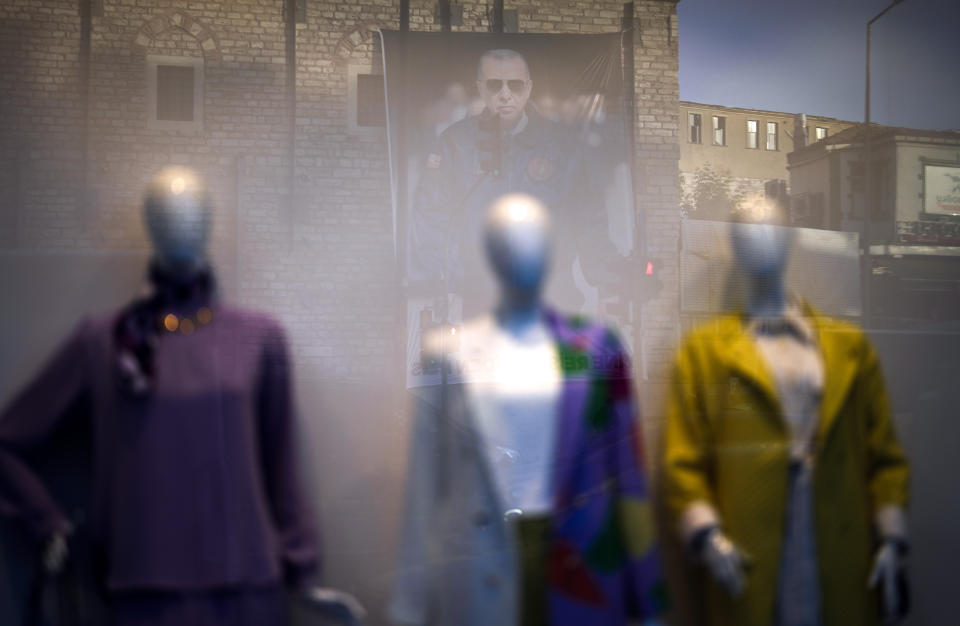 A reflection of a poster of Turkish President and People's Alliance's presidential candidate Recep Tayyip Erdogan, is seen on the glass of a clothing shop in Istanbul, Turkey, Tuesday, May 23, 2023. Two opposing visions for Turkey’s future are on the ballot when voters return to the polls Sunday for a runoff presidential election, which will decide between an increasingly authoritarian incumbent President Recep Tayyip Erdogan and challenger Kemal Kilicdaroglu, who has pledged to restore democracy. (AP Photo/Khalil Hamra)