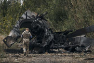 FILE - A Ukrainian soldier passes by a Russian tank damaged in a battle in a just freed territory on the road to Balakleya in the Kharkiv region, Ukraine, on Sept. 11, 2022. Ukraine has successfully pressed its counteroffensive, forcing Russian troops to retreat in several areas of the east and the south. (AP Photo, File)