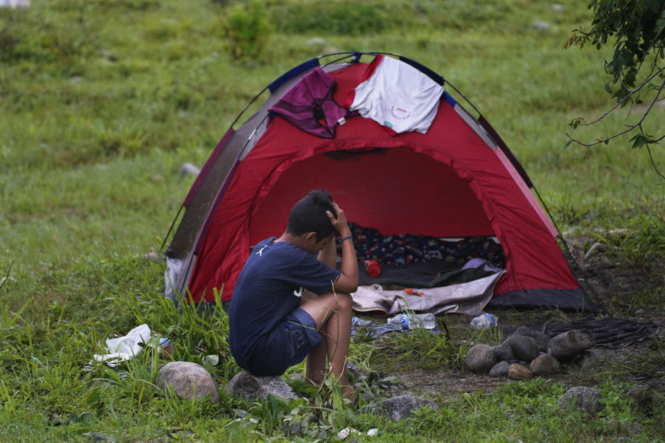 A migrant man sits outside a pop up tent on the banks of the Huixtla River, Chiapas state, Mexico, Wednesday, June 8, 2022. A group of migrants, many from Central America and Venezuela, left Tapachula on Monday, tired of waiting for their status in a region with little work and far from their ultimate goal of reaching the United States. (AP Photo/Marco Ugarte)