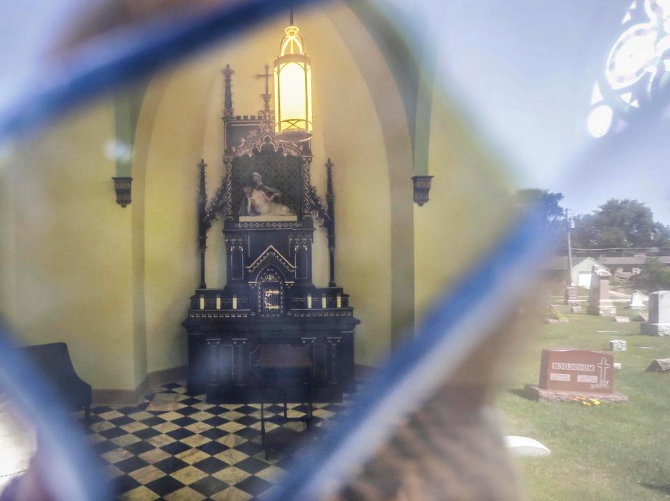 A view inside the Fr. Michael Haider Chapel at Calvary Cemetery as seen through the stained glass windows of the doors at the facility, Tuesday, August 9, 2022, in Sheboygan, Wis. On the day of his funeral in 1885, business places in the city closed and the funeral cortege reached from Holy Name Church to the cemetery, a mile away.