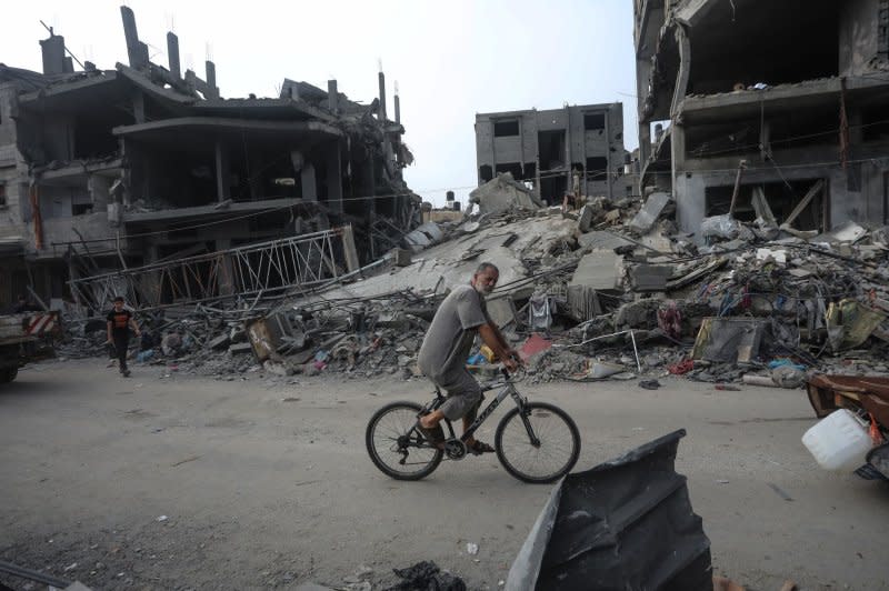 A Palestinian man riding a bicycle past a destroyed building in the aftermath of Israeli bombing in Rafah in the southern Gaza Strip on Saturday as Israel announced the war had entered a 'new phase.' Photo by Ismael Mohamad/UPI